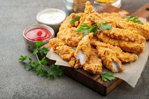 Breaded chicken strips with two kinds of sauces on a wooden Board. Fast food  Stock Photos