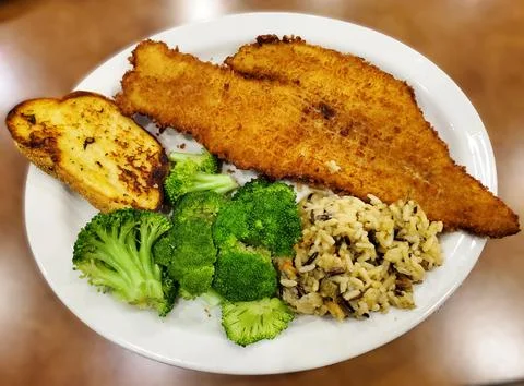 Breaded cod fish fillet served with steamed broccoli, mixed rice, vegetable.. Stock Photos