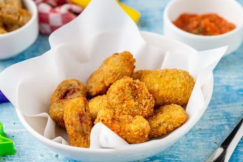 Breaded deep fried chicken and coated potato bites Stock Photos