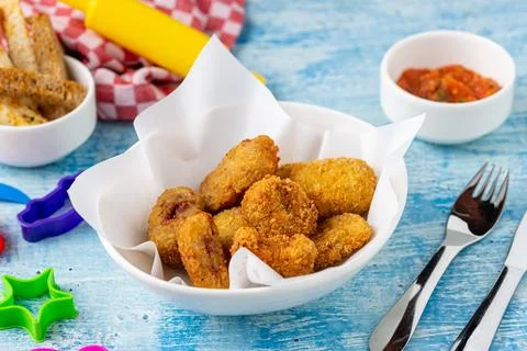 Breaded deep fried chicken and coated potato bites Stock Photos