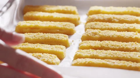 Breaded fish sticks are arranged in neat rows on parchment paper just from the o Stock Footage 321863777