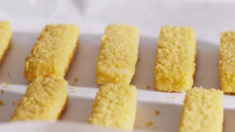 Breaded fish sticks are arranged in neat rows on parchment paper just from the o Stock Footage 321864925