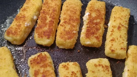 Breaded fish sticks while cooking Stock Footage 311578374
