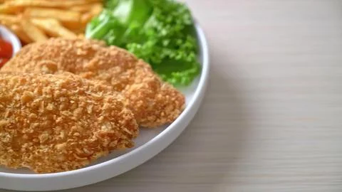 Breaded fried chicken cutlet with fresh salad on white plate Stock Photos