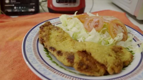 Breaded Fried Fillet Served With Lettuce and Tomato Salad on a Plate Stock Footage 345365463