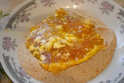 Breaded meat cutlet being coated in egg and breadcrumbs Stock Photos
