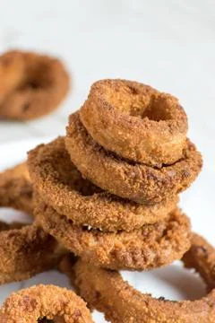 Breaded onion rings in stack on white background Stock Photos