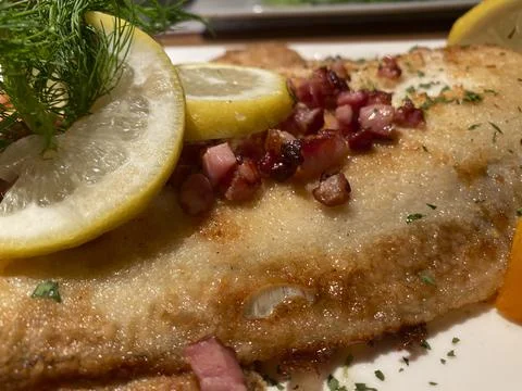 Breaded plaice with bacon cubes and lemon, German recipe from the coast Stock Photos