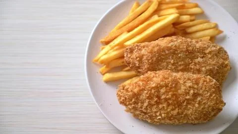 Breaded pork cutlets with sliced apples on white plate Stock Photos