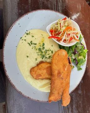 Breaded schnitzel with mashed potatoes and fresh vegetable salad. Stock Photos