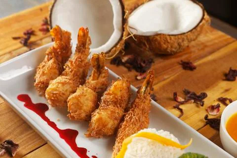 Breaded shrimp with Coconut shell in Jamaican sauce, accompanied by steamed r Stock Photos