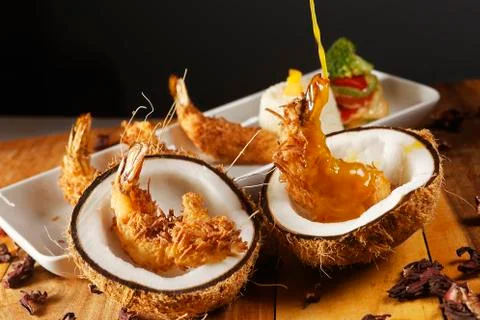 Breaded shrimp with Coconut shell in Jamaican sauce, accompanied by steamed r Stock Photos