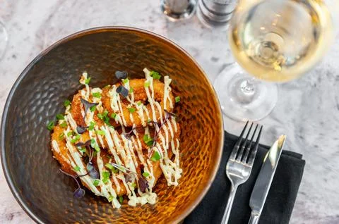 Breaded squid rings deep fried with a glass of white wine Stock Photos