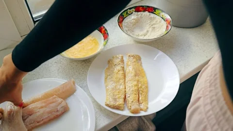 Breading Fresh Pollock Fillet at Kitchen Counter Preparing Healthy Meal Stock Footage 325957831