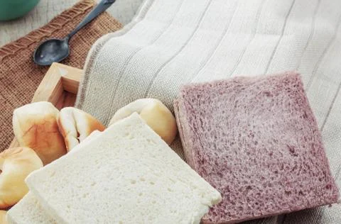 Breads and cups on tablecloth. Stock Photos