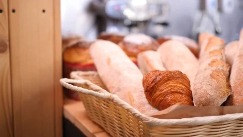 Breads and other bakery in decorative basket on wooden bakery shelve in Stock Footage 105860227