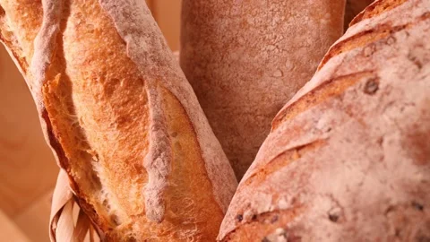 Breads and other bakery in decorative basket in background close up slow motion Stock Footage 147727504