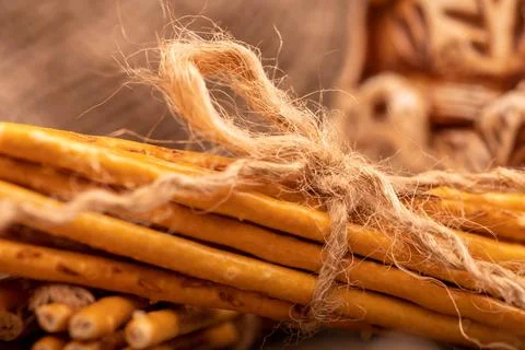 Breadsticks with salt tied with string and an earthenware mug for tea. Close- Stock Photos