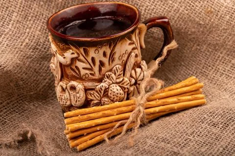 Breadsticks with salt tied with string and an earthenware mug for tea. Close- Stock Photos