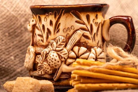 Breadsticks with salt tied with string and an earthenware mug for tea. Close- Stock Photos
