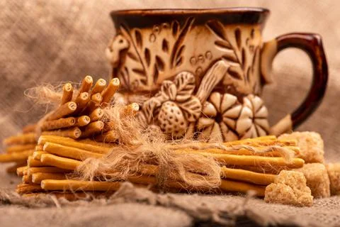 Breadsticks with salt tied with string and an earthenware mug for tea. Close- Stock Photos