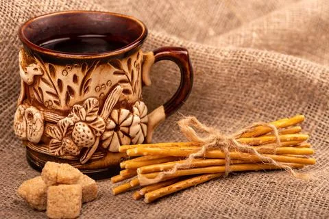 Breadsticks with salt tied with string and an earthenware mug for tea. Close- Stock Photos