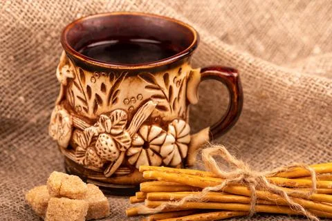 Breadsticks with salt tied with string and an earthenware mug for tea. Close- Stock Photos