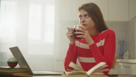 In the break between tasks, the woman drinks tea and dreams about something. Stock Footage 270738658