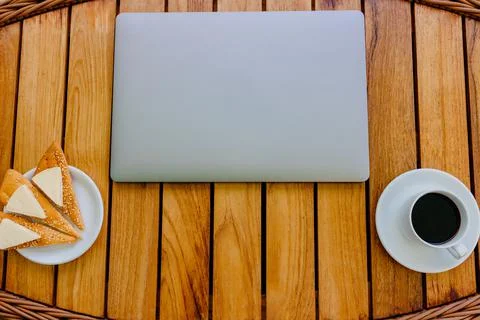 Break concept. Flat lay view of a workspace with a closed laptop on wooden table Stock Photos