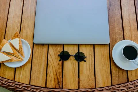 Break concept. Flat lay view of a workspace with a closed laptop on a brown Stock Photos