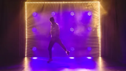 Break dance performed by a young guy in a tracksuit. Silhouette of a male dancer Stock Footage 138365849