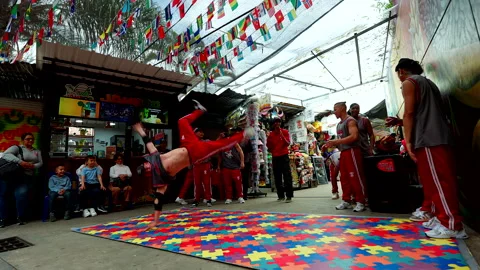 Break dancers performing a street dance show on a colorful puzzle mat Stock Footage 334607370