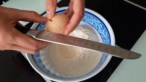Break the egg into the bowl with the flour Stock Footage 287332616