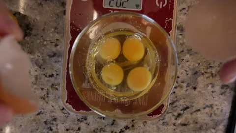 Break an egg into a bowl Stockbeeldmateriaal 166543427
