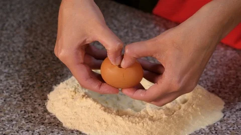 Break an egg into the flour Stock Footage 97939362