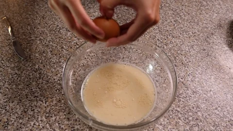 Break an egg in milk slow motion Stock Footage 96231627