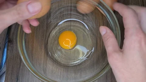 Break eggs in a transparent bowl Stock Footage 165542775