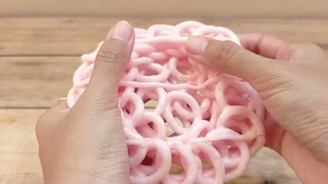 Break a pink rice cracker into to pieces Stock Footage 145377718