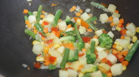 Break raw eggs in a pan roasting vegetables Stock Footage 49603249