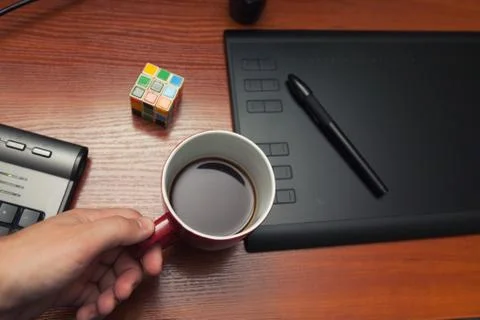 Break, rest during the work process, a cup of coffee, a cube of rubik, a puzz Stock Photos