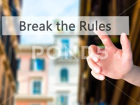 Break the Rules - Hand pressing a button on blurred background c Stock Photos