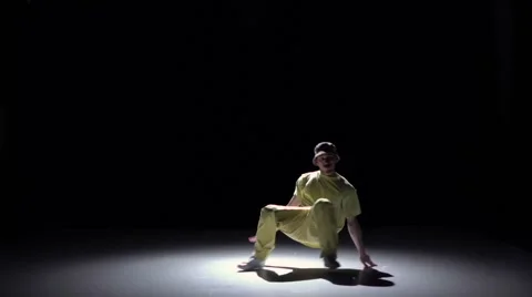 Breakdance dancer in yellow suit continue dance on black, shadow, slow motion Video stock 61178507