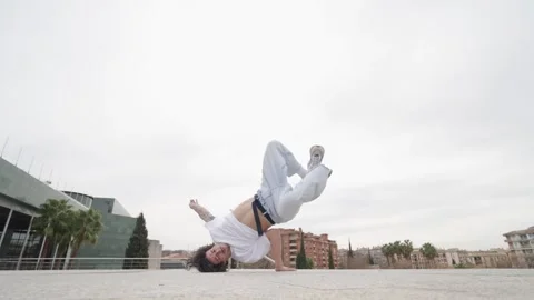 Breakdancer performing acrobatics outdoors in urban setting Stock Footage 305497749
