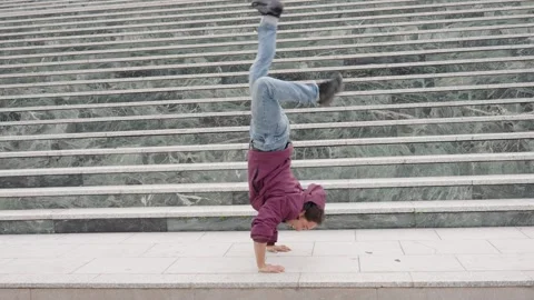 Breakdancer performing acrobatics on urban stairs Stock Footage 308917015