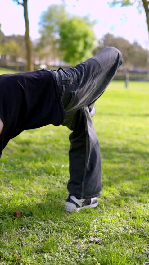 Breakdancer performing backflip in public park Stock Footage 327336142