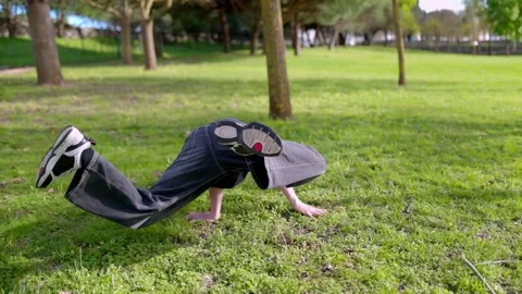 Breakdancer performing freeze moves in a park Stock Footage 316958102