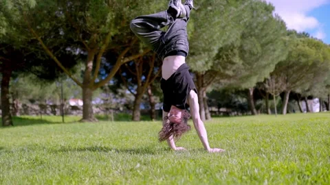 Breakdancer performing handstand and finishing with applause in park Stock Footage 316958111