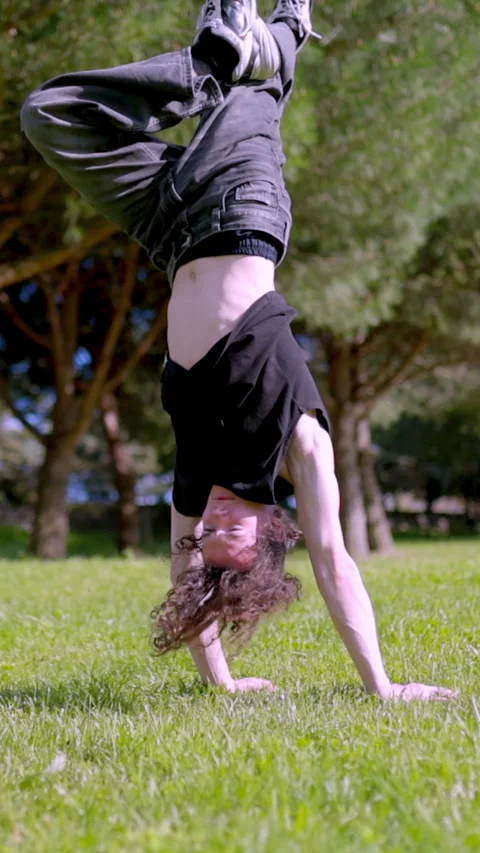 Breakdancer performing handstand and finishing with applause in park Stock Footage 327336254