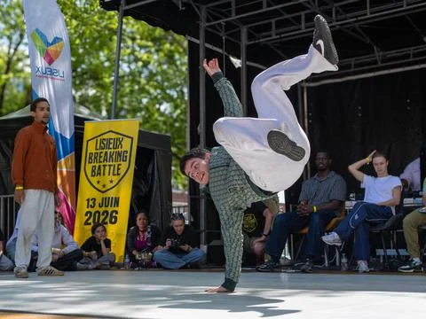 Breakdancer performing a handstand during competition Stock Photos