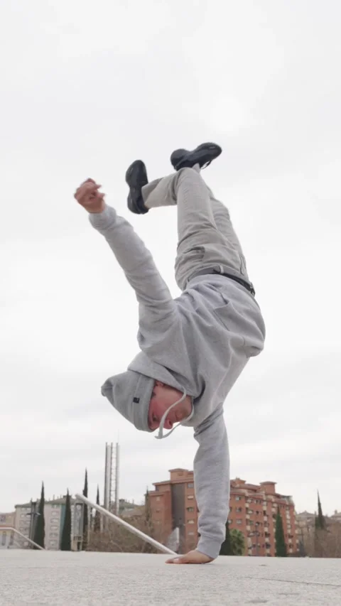 Breakdancer performing handstand freeze in urban setting Stock Footage 305911085